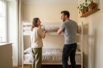 Couple adulte aménageant un lit superposé moderne dans un appartement au design scandinave épuré